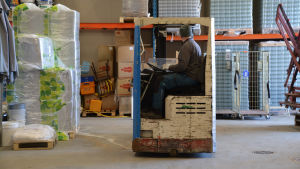 Tomas Bruce har fullt upp. Tomas Bruce sitter i sin truck och kör inne i en stor industrihall.
