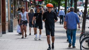 En man med en "coronahatt" som signalerar avstånd. Larmet går om någon eller något kommer på mindre än 1,5 meters avstånd. En man med en "coronahatt" som signalerar avstånd. Larmet går om någon eller något kommer på mindre än 1,5 meters avstånd.