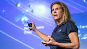 Doktor Lori S. Glaze har ansvar för Nasas forskning och rymdflygningar. Lori Glaze framför en illustration av solsystemet.