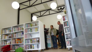 Tenala fick nyss ett nytt bibliotek som i framtiden kan bli meröppet. Filialbibliotek, ljusa bokhyllor och tre män som står och pratar, en håller papper i handen.