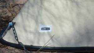 Då man har betalat registeraringsavgiften får man en lapp som klistras på båten. En upp och nervänd båt på en strand.