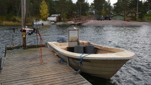 Undvik stora fester också ute på holmarna i skärgården. Arkivbild. Den vitgula fiskebåten är fastbunden vid träbryggan.