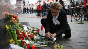 Många sörjde de som dött i attacken. En kvinna lägger ner blommor och tänder ljus vid minnesplatsen i tyska Hanau.