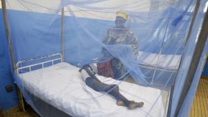 En kvinna vakar över ett barn som insjuknat i malaria Kvinna vakar över ett barn som insjuknat i malaria