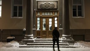 Den entren har Holmström och Sundström använt många gånger. Entre till stor stenbyggnad. Trappor och utsmyckad dörr. Vid trappan snö och person som vandrar förbi.