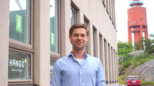 Hangö turismchef Jon Lindström tycker privatinkvartering är ett välkommet komplement. Jon Lindström framför Hangö stads turistbyrå med vattentornet i bakgrunden.