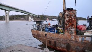 Skrotbåten, Emsalö bro och i bakgrunden Borgå sjöbevakningsstation. Skrotbåten bogserad till bryggan invid Emsalö bro 15.01.20