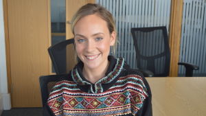 Emily Baldwin tycker det är skönt att inte måsta höra om brexit mer. En kvinna (Emily Baldwin) ler rakt in i kameran. Hon sitter i ett kontorsrum och bakom henne finns två svarta kontorsstolar och ett bord.