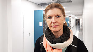 Minna Scheinin tycker det är bra att yrkeshögskolans studerande får praktisk erfarenhet av att leda grupper. Blond kvinna i korridor.