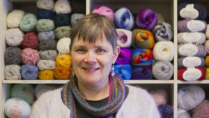Ann-Louise Robertsén säger att affärerna går bra nu när intresset för stickning är stort. En kvinna med kort ljusbrunt hår står framför en hylla fylld med garn.