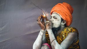 En sadhu, helig indisk man, tar sig en rök under Kumbh Mela - festivalen i norra Indien, som pågår från den 15 januari till 4 mars. Indisk helig man röker vid sitt tält under Kumbh Mela festivalen 2019