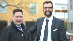 Eniga västnyländska rikspolitiker, Thomas Blomqvist och Johan Kvarnström. Dessutom flitiga tågresenärer på kustbanan. Två män i slips och kostym ler mot kameran.