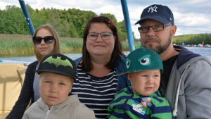 Längst bak från vänster: Eveliina, 14 år, Kirsi Kaarela och Timo Siitonen. I famnen från vänster barnen Onni, 5 år, och Oiva, 2 år. En familj med två vuxna å två barn sitter i ett kryssningsfartyg.