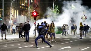 Demonstranter intog gatorna i Belgrad. På bilden gata i Belgrad där demonstranter springer. De omges av rök.
