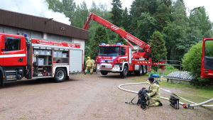 Räddningsverket var snabbt på plats. Två brandbilar och brandmän bredvid ett rykande hus.