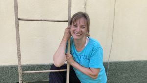 Solveig Ekholm, danslärare vid Arkipelag, säger att lägret är ett bra sätt att komma tillbaka till dansandet efter sommarpausen. En kvinna med turkos blus lutar sig mot en stege framför en gul tegelvägg.