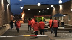 Det ska vara låg tröskel för ungdomar att vara i kontakt med Nattvandrarna. En grupp mänskor i röda jackor i ett bostadsområde.