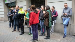 Jesús Fabá från grannskapet pratar med polisen inför den stundande avhysningen av en familj. Knappt tjugo personer har samlats på en trottoar i Barcelona för att diskutera.