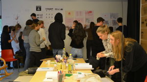 KTH-studerandena träffade Vasa stads planläggningsavdelning och fick information om Vasa och projektet på tisdagen. En grupp unga människor klistrar upp affischer.