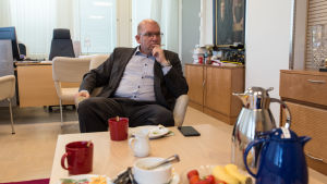 Riku Aalto säger att facket har fått ett klart budskap från fältet, om att arbetstidsförlängningen ska bort. Industrifackets ordförande Riku Aalto sitter framför ett lågt bord med frukost på. I förgrunden syns en kaffekanna och en mjölkkanna.