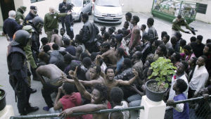 Unga marockaner har tagit sig över gränsen till Spanien, till staden Ceuta. Migranter firar, omgivna av spanska myndigheter, efter att de lyckats ta sig över gränsstängslen till Ceuta 17.2.2017