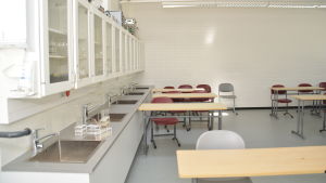 Det här är matematik- och fysiksalen i B-huset. Här har trägolvet bytts ut till ett golv med matta. Ett klassrum i Karjaan yhteiskoulu där man har matematik och fysik.