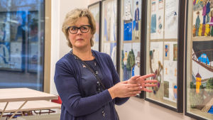 Carola Wiksten visar upp ett konstverk i matsalen. Eleverna har varit med och skapat det. Carola Wiksten står vid konstverk i skolmatsal