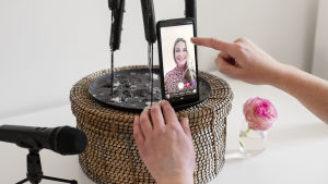 En ljusstake får agera hemmagjort stativ för mobiltelefonen. Anne Hietanen gör en Instagram-live.