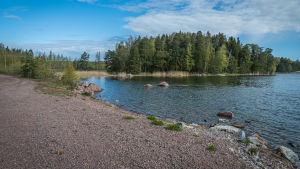 Udden är ett naturskönt område. En vy över en vik vid stranden, solen skiner