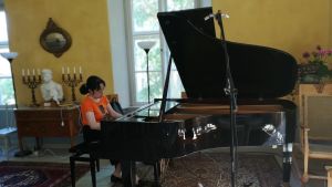 Den japanska pianisten Sae lida i festsalen på Korpo gård. Den japanska pianisten Sae Iida vid flygeln i Korpo gårds festsal
