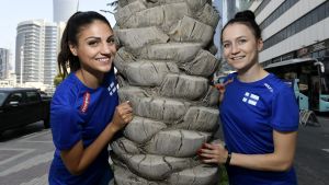 På lördag börjar VM för häckdamerna. Nooralotta Neziri och Reetta Hurske står vid en palm och ler in i kameran.