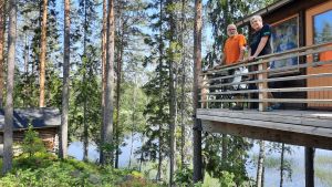Eftersom utländska turister uteblev, satsar Henrik Wiik och Ulla-Beth Mäki-Jussila starkare på inhemska besökare En man och en kvinna står lutade mot ett staket uppe i en trähuskoja i skogen