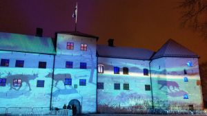 Ljuskonstverket Luminous Finland vid Åbo slott i december. Renar, en björn och Finlands natur projiceras på Åbo slotts fasad i vinternatten i ljusinstallationen Luminous Finland 100.