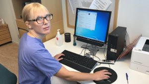 Allmänläkaren Hanna Åsberg vill att vårdcentralerna utvecklar digitaliseringen. "Samarbetet mellan vårdpersonalen och it-teknikerna borde bli bättre", säger hon. Allmänläkaren Hanna Åsberg sitter framför en dator i ett mottagningsrum på en vårdcentral.