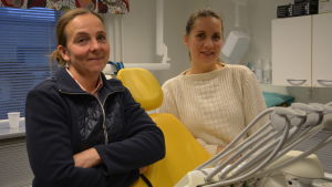 Ansvariga munhygienisten Barbro Mattsson-Salminen och ledande tandläkare Aura Kirvelä säger att läget är lugnt på tandcentralen i Pargas. Två kvinnor står framför en tandläkarstol