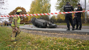 Händelsen sägs ha börjat med att en man krupit ur en bil som låg upp och ner och då stulit ambulansen. En personbil ligger upp och ned, räddningspersonal och poliser rör sig brevid den.