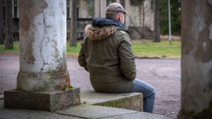 Psykosociala faktorer som att man upplever sig vara ensam kan öka risken för att utveckla ett problem med spelande. man sitter med ryggen mot kameran