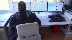 Sjukvårdare Miika Hokkanen vid datorn i sjöbevakningsstationens kontor. Sjukvårdare Fältledare Miika Hokkanen framför datorer i Kuggen.