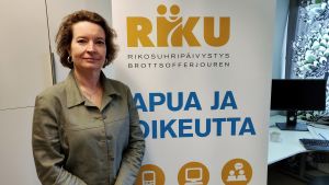 Leena-Kaisa Åberg på Brottsofferjouren tycker att man måste tänka på de utsattas säkerhet. kvinna står framför en roll-up i ett kontor