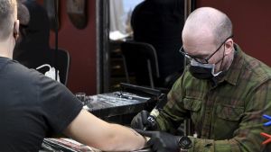 – Finland är bra på tatueringssäkerhet, säger Tony Raita som är ordförande för Finlands tatueringskonstnärsförening. Tony Raita tatuerar en kund.