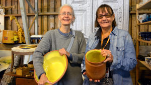 Lena Kolmvik och Patricia Serrander säljer gula lergods från Gävle lerfabrik. Lena Kolmvik och Patricia Serrander från Stockholm håller i lerkärl med gul insida.