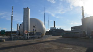 Mängden biogas som produceras på Käringmossen i dag är bara en tiondel av mängden deponigas man får från den gamla soptippen. Biogasanläggningen med pipor och gasbehållare.