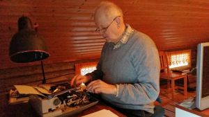 Antti Tuuri skriver fortfarande sina böcker på en vanlig skrivmaskin. Antti Tuuri vid skrivmaskinen i sitt arbetsrum.