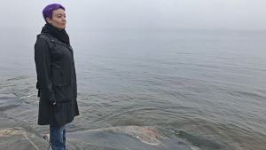 Karolina Luodon mielestä ihmisten vetäytyminen surevan ympäriltä on inhimillistä. Karoliina Luoto seisoo kalliolla meren rannalla ja ilma on sumuinen.
