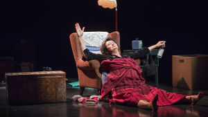 Heidi Heralan näyttelemä Everstinna röhnöttää maassa nojatuolin edessä viinapullo kourassaan, autuallinen ilme kasvoillaan.
