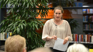 Forskaren Marissa Mehr presenterade de finska verken. Kvinna som talar inför publik.