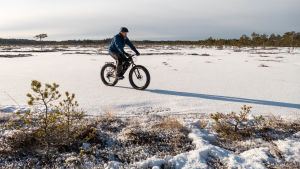 Med terrängcykel tar man sig fram också på is och skare. En terrängcyklist som cyklar på skaren vintertid.