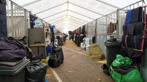 Inne i de temporära stallen står hästarna på rad. Inne i ett temporärt stall på Helsinki International Horse Show.