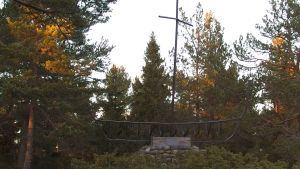 Monumentet "Havets offer" på Rosala Monument av metall och sten som föreställer en båt med mast. Står bland träd i höstliga färger