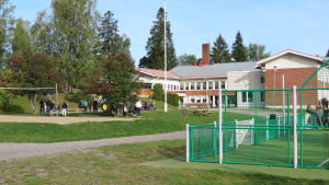 Det finns gott om plats att röra sig utomhus, men pojkarna, som alla går i de högre klasserna, flockas runt traktorn. Den är just den dagens sevärdhet på skolområdet i Tenala. En skolbyggnad i rött tegel. Höjdems skola i Tenala. Tidig höst, spetember. Blå himmel.